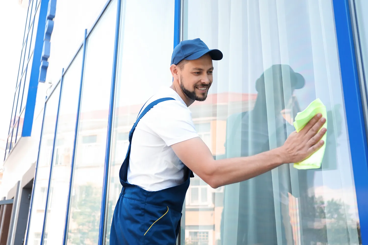 Mann putzt Fensterglas von außen von Hanane Mierau Zaid